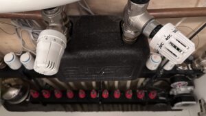 De thermostaatkranen boven de verdeler / The thermostatic valves on top of the manifold